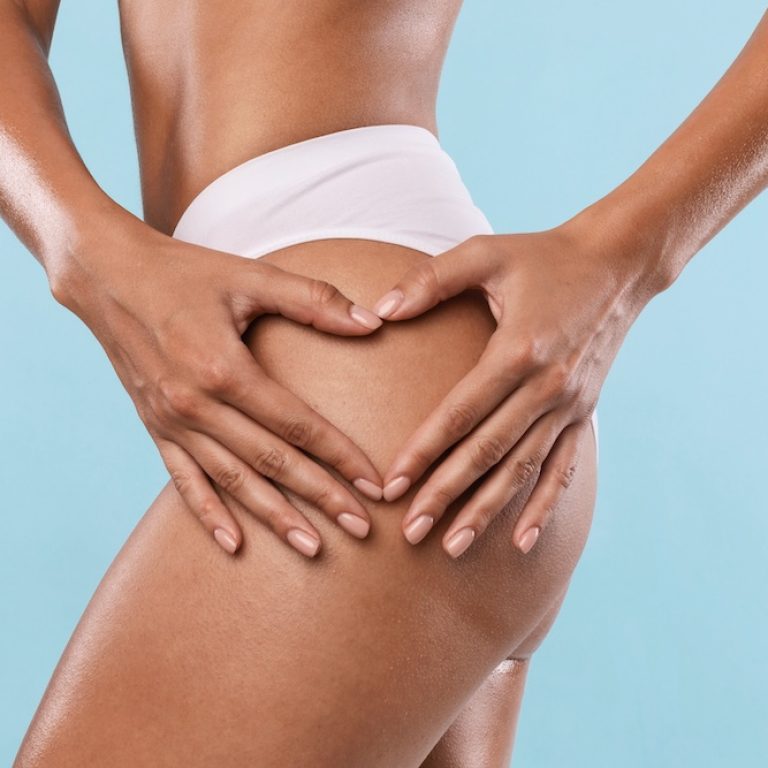 Love Yourself Concept. Closeup cropped view of unrecognizable slim woman making heart sign gesture with hands on her buttocks isolated over blue studio background, banner. Anti cellulite massage